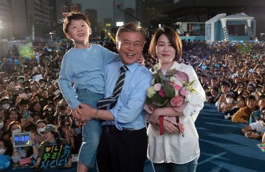 문재인 전 대통령이 2017년 5월 8일 대선 마지막 유세에서딸 다혜씨와 손자로부터 카네이션을 받은 뒤 미소짓고 있다. 연합뉴스