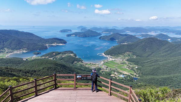 경남 거제시 동부면 노자산 정상 덱 전망대에 서면 동서남북 전망이 열린다. 서쪽 쪽빛 바다 멀리 연화도 욕지도 두미도가 보이고 그 앞으로 비진도 용초도 추봉도 한산도 등이 파노라마로 펼쳐지는 다도해 조망 맛집이다. 발아래 탑포항과 율포항이 역 하트 모양을 했다.(드론촬영)