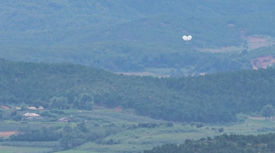 지난 7월 24일 경기 파주시 오두산통일전망대에서 바라본 북한 개풍군 마을 일대에서 오물풍선이 상공으로 오르고 있다. 뉴스1