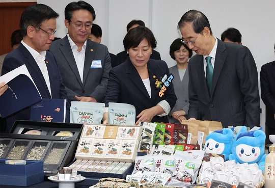 한덕수 국무총리와 송미령 농림축산식품부 장관 및 국무위원들이 쌀 가공식품, 과일, 전복, 해조류 등 국산 농수산식품 소비 촉진 및 추석 민생 선물세트 홍보 행사에서 제품을 살펴보며 시식하는 모습. (출처 : 뉴시스)