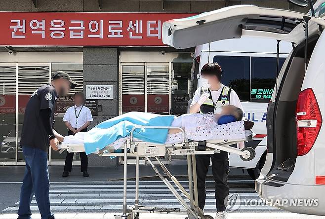 이송되는 환자 (서울=연합뉴스) 김성민 기자 = 전국 곳곳에서 응급실 운영이 파행하는 가운데 정부가 4일 군의관 등 보강 인력을 긴급 배치했다. 
    이날 서울 양천구 이화여자대학교 목동병원 응급의료센터 인근에서 한 환자가 이송되고 있다. 2024.9.4 ksm7976@yna.co.kr