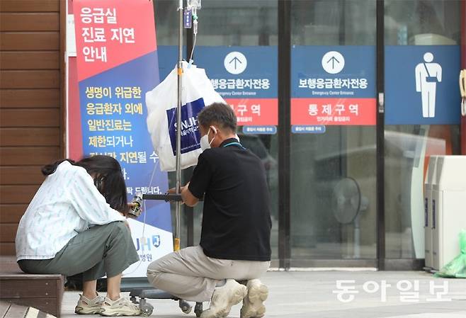 8일 오후 서울 종로구 서울대병원 응급실 앞에서 환자(왼쪽)와 보호자가 순서를 기다리며 앉아 있다. 최근 응급의료 공백이 확산되면서 대형병원 응급실에서 수용을 거절당하거나 진료가 지연되는 경우가 늘고 있다. 신원건 기자 laputa@donga.com