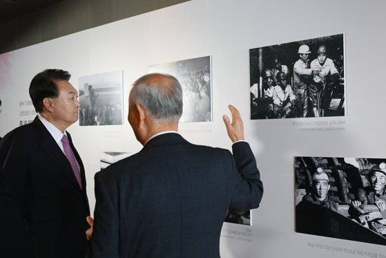 윤석열 대통령이 지난해 10월 4일 서울 광진구 그랜드 워커힐 서울에서 열린 파독 근로 60주년 기념 오찬에 앞서 파독 근로자의 독일 현장 모습을 담은 사진을 관람하고 있다. 연합뉴스