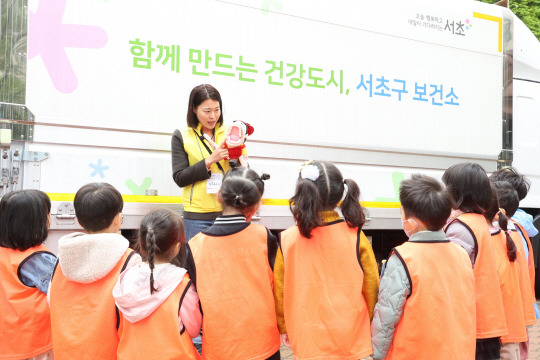 서울 서초구에서 운영하는 ‘찾아가는 보건소 건강체험관’ 행사에서 어린이들이 구강건강관리 부스에서 설명을 듣고 있다. 서초구청 제공