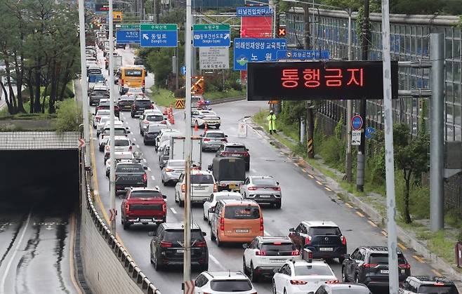 (서울=뉴스1) 임세영 기자 = 경찰이 17일 서울 노원구 수락지하차도 입구를 통제해 인근도로가 정체되고 있다. 서울시는 중부지방 집중호우로 중랑천 수위가 상승함에 따라 이날 오전 9시 7분부로 동부간선도로 전구간(수락지하차도~성수JC)을 통제한다고 밝혔다. 2024.7.17/뉴스1 /사진=뉴스1화상