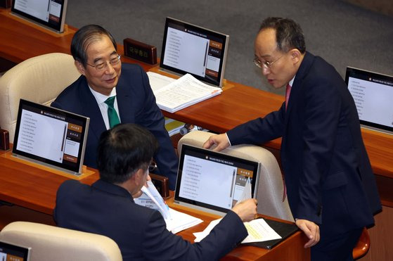 추경호 국민의힘 원내대표(가운데)가 11일 오후 서울 국회에서 열린 대정부질문(경제 분야)에서 한덕수 국무총리, 최상목 경제부총리 겸 기획재정부 장관과 대화하고 있다. 뉴시스