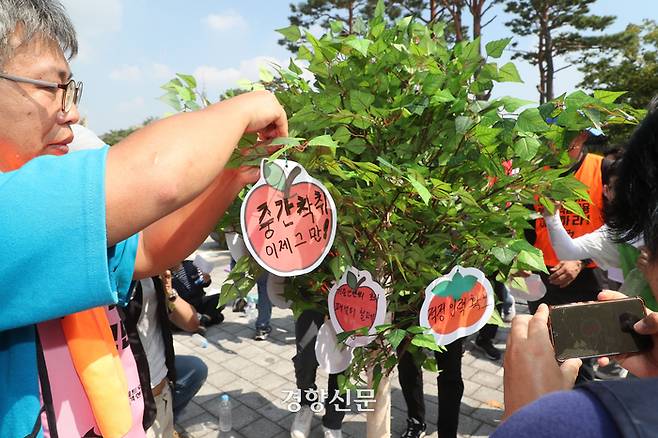 민주노총 공공운수노조 조합원들이 11일 서울 용산 대통령실 앞에서 열린 ‘모두 함께 풍성한 한가위! 차별 해소 예산부터! 공공부문 비정규직 차별 해소 촉구 추석 한마당’에서 노동자들의 바람을 적은 소원지를 소원나무에 걸고 있다. 정지윤 선임기자