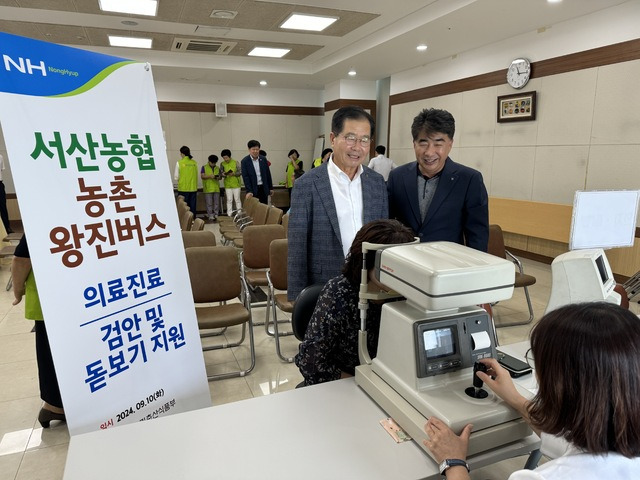 10일 충남 서산농협에서 열린 ‘농촌 왕진버스’ 행사에서 이상윤 조합장(왼쪽)과 백남성 본부장이 눈 검사를 받는 한 조합원을 살펴보고 있다.