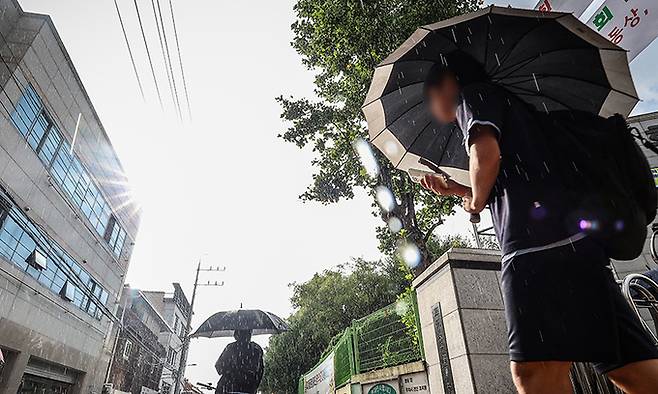 11일 한 중학교 앞에서 학생들이 우산을 쓰고 하교하고 있다. 연합뉴스