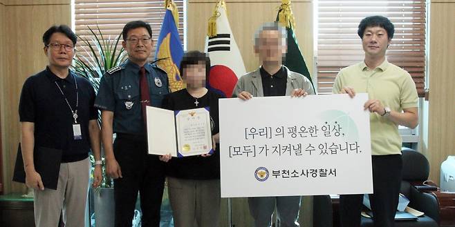 보이스피싱 신고한 택시기사 부부(사진 가운데) [부천소사경찰서 제공. 재판매 및 DB 금지]