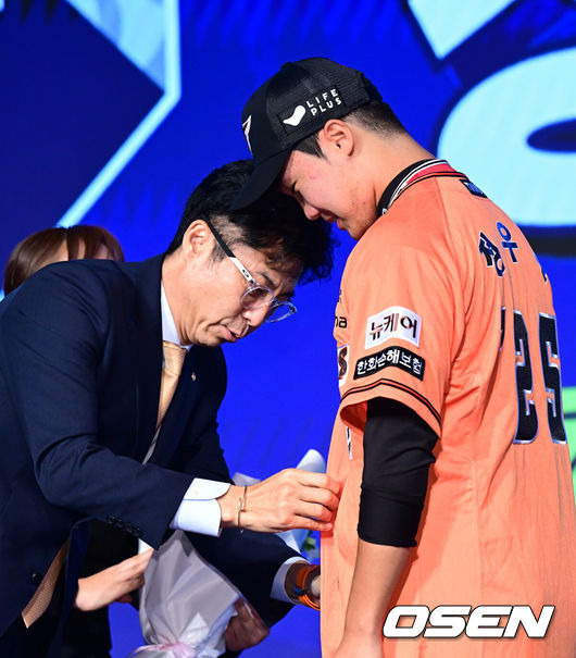 [OSEN=지형준 기자] 11일 오후 서울 잠실 롯데호텔 월드에서 2025 KBO 신인 드래프트가 열렸다.2025 KBO 신인 드래프트는 전면 드래프트 방식으로 진행된다. 지명은 1라운드부터 11라운드까지 이뤄지며, 2023년도 구단 순위의 역순인 키움-한화-삼성-롯데-KIA-두산-NC-SSG-KT-LG 순서로 실시된다.전주고 정우주가 한화에 지명되며 손혁 단장이 유니폼을 전달하고 있다. 2024.09.11 / jpnews@osen.co.kr