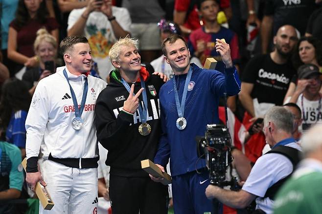 2024 파리 올림픽 수영 남자 평영 100m 시상식에서 애덤 피티(Adam Peaty, 영국, 왼쪽부터), 니콜로 마르티넨기(Nicolo Martinenghi, 이탈리아), 닉 핑크(Nic Fink, 미국) 선수가 빅토리 셀피를 찍고 있는 모습