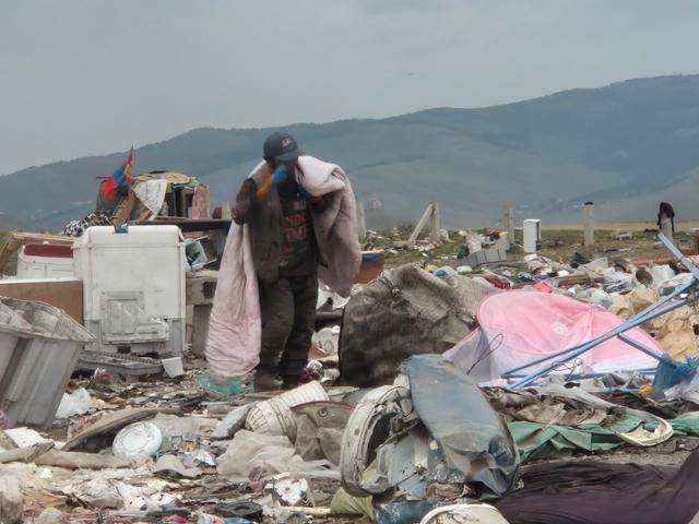 지난달 30일 몽골 수도 울란바토르에서 차량으로 1시간 정도 떨어진 울란촐로트 쓰레기 매립장에서 한 사내가 본인이 사용하려는 듯 쓰레기 더미 속에서 찾아낸 이불을 지고 있다. 기후변화 등 각종 이유로 빈민이 된 몽골 주민 중에는 이처럼 먹고살기 위해 쓰레기장에서 폐기물을 줍는 경우도 있다. 한때 이곳에서 생활했던 베 솝드는 "200~300명은 될 것"이라고 말했다. 울란촐로트=최나실 기자