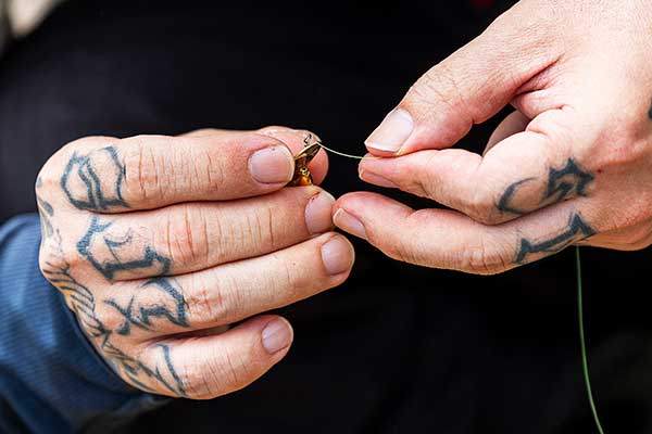 루어에 낚싯줄을 끼우고 있다.