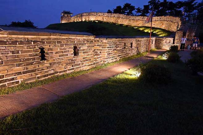 A family take a nighttime stroll along the stone walls of Suwon's Hwaseong. (Korea Tourist Organization)