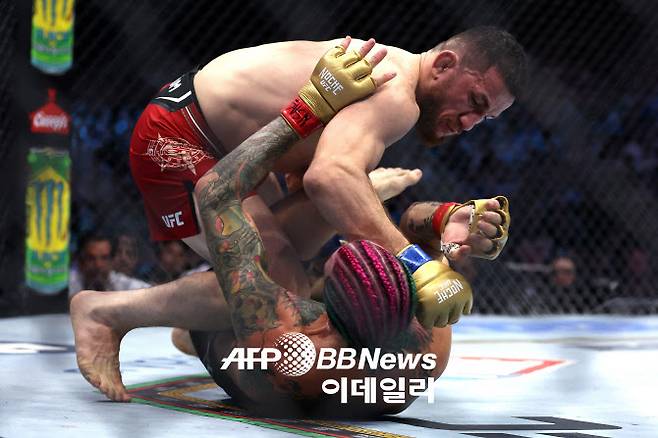 UFC 밴텀급 타이틀매치에서 도전자 메랍 드발리쉬빌리가 챔피언 션 오말리를 그라운드에서 압박하고 있다. 사진=AFPBBNews