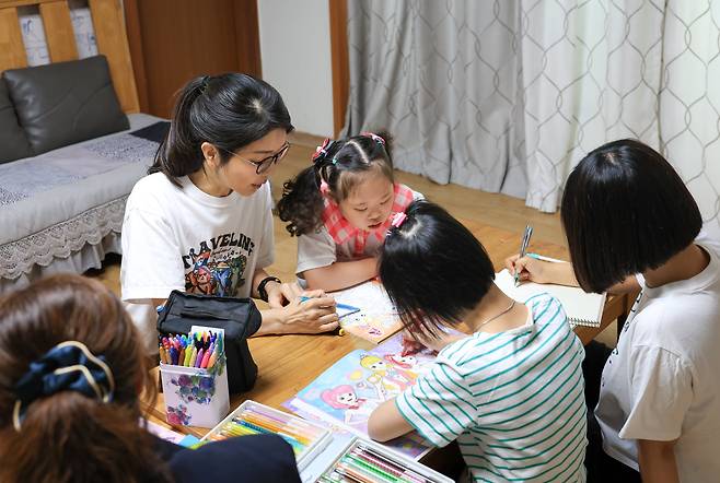 윤석열 대통령 부인 김건희 여사가 15일 오후 서울 은평구 장애 아동 거주 시설인 다움장애아동지원센터를 찾아 아이들이 그림책에 색칠하는 것을 돕고 있다. /대통령실