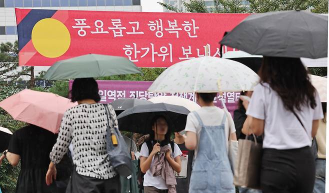 지난 13일 오후 서울 용산역에서 우산을 쓴 시민들이 발걸음을 재촉하고 있다. /뉴스1