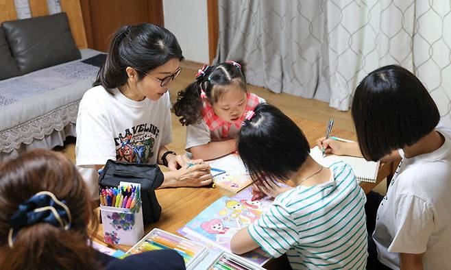 김건희 여사가 지난 15일 서울 은평구 다움장애아동지원센터에서 아이들의 그림그리기를 도와주고 있다. 대통령실 제공