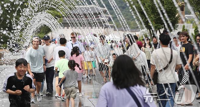 추석 명절 연휴인 15일 오후 서울 광화문광장에서 시민들이 폭염특보를 피해 터널분수를 지나고 있다. 2024.9.15/뉴스1 ⓒ News1 임세영 기자