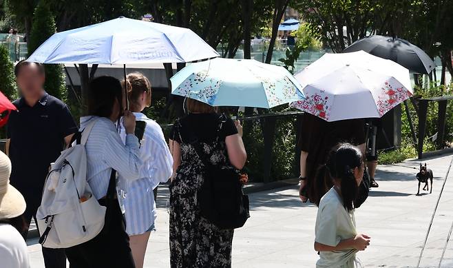 추석 연휴인 16일 서울 종로구 광화문광장에서 외국인 관광객들이 양산을 쓰고 걸어가고 있다. /연합뉴스