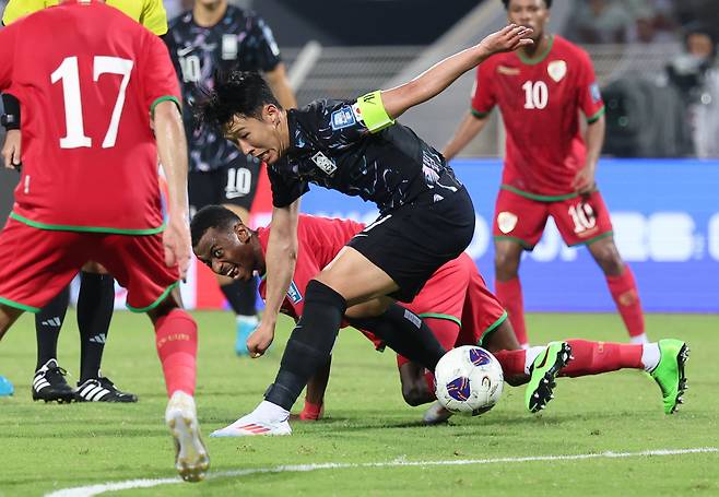 Son Heung-min (center) of South Korea dribbles the ball past the Oman defenders during the World Cup qualification match at the Sultan Qaboos Sports Complex in Muscat on Sept. 10. (Yonhap)