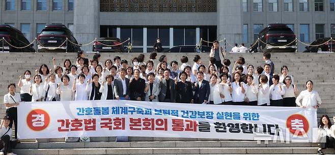 [서울=뉴시스] 조성봉 기자 = 지난달 28일 오후 서울 여의도 국회에서 열린 제417회국회(임시회) 제2차 본회의에서 간호법안(대안)이 재적300인 중 재석 290인, 찬성 283인, 반대 2인, 기권 5인으로 통과된 가운데 대한간호협회 소속 간호사들과 박주민 보건복지위원장을 비롯한 의원들이  본청 계단에서 기념촬영을 하고 있다. 2024.08.28. suncho21@newsis.com