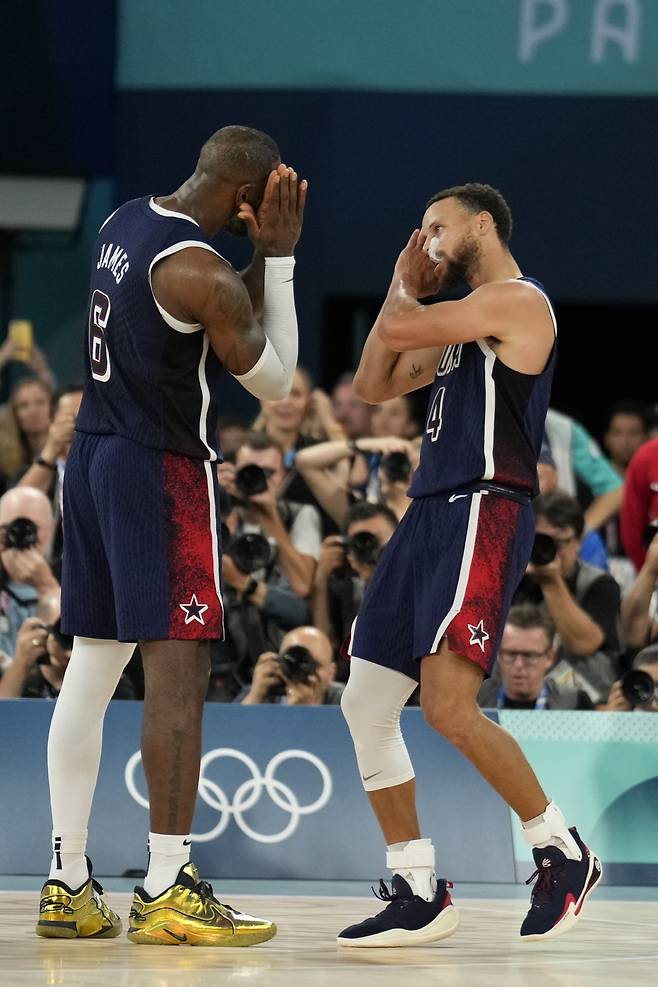 United States' Stephen Curry (4) and LeBron James (6) celebrate after beating France to win the gold medal during a men's gold medal basketball game at Bercy Arena at the 2024 Summer Olympics, Saturday, Aug. 10, 2024, in Paris, France. (AP Photo/Mark J. Terrill)







<저작권자(c) 연합뉴스, 무단 전재-재배포, AI 학습 및 활용 금지>