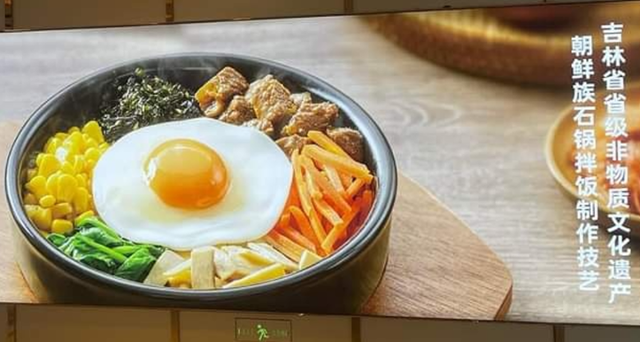 지난달 중순 중국 우한 시 한 상점가에 붙어있는 중국 비빔밥 프랜차이즈 광고 사진. 오른쪽 옆에는 흰 글씨로 "조선족 돌솥 비빔밥 조리기술은 지린성 성급 무형문화유산이다"