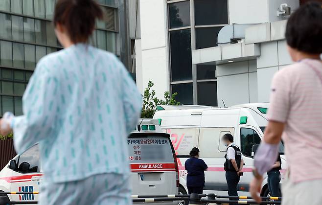 18일 오후 서울 시내 대학병원 응급의료센터 앞에 도착한 구급차에서 환자 보호자와 의료진이 응급실 풀베드 상황에 대기하고 있다. 뉴스1