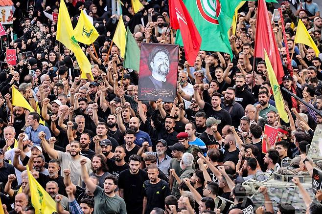 18일(현지시간) 레바논 남부 베이루트에서 무선호출기(삐삐) 폭발로 숨진 희생자 장례식서 주민들이 추모를 하며 구호를 외치고 있다. 2024.09.19 ⓒ AFP=뉴스1 ⓒ News1 우동명 기자