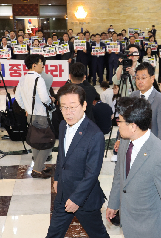 국민의힘 의원들이 19일 오후 '김건희 여사 특검법' 등을 단독 강행 처리하려는 거대야당을 규탄하는 가운데 더불어민주당 이재명 당대표를 비롯한 의원들이 국회 본회의장으로 들어가고 있다.<연합뉴스 사진>