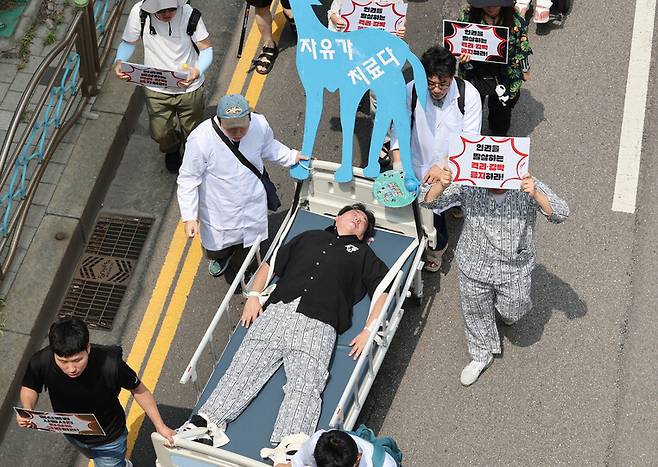 8월9일 오전 한국정신장애인연합회 등 29개 정신장애인 단체 회원들이 환자를 침대에 강박하는 행위극을 하며 부천시 원미구 부천W진병원 앞에서 부천시 보건소까지 행진하고 있다. 김영원 기자 forever@hani.co.kr