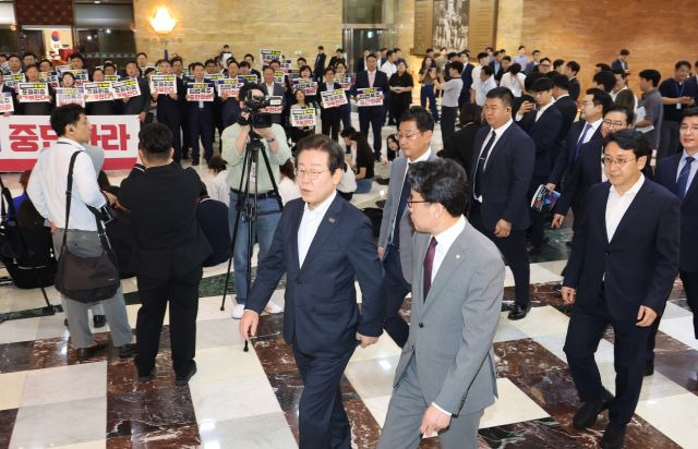 국민의힘 의원들이 19일 오후 '김건희 여사 특검법' 등을 강행 처리하려는 야당을 규탄하는 가운데 이재명 더불어민주당 대표를 비롯한 의원들이 서울 여의도 국회 본회의장으로 들어가고 있다. 연합뉴스