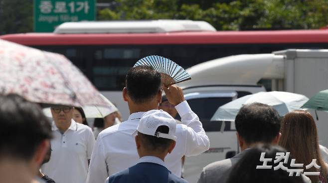 광화문사거리에서 한 시민이 부채로 햇빛을 가리고 있다. 박종민 기자