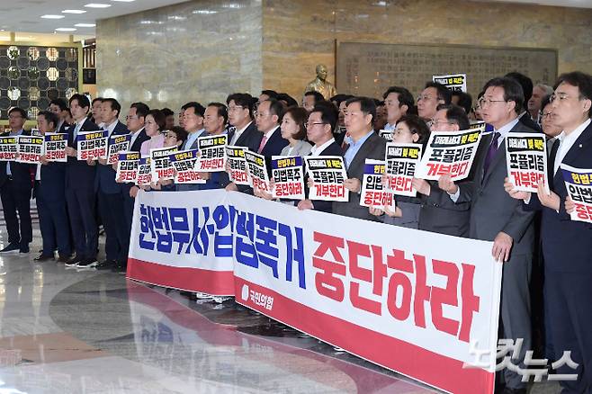 국민의힘 추경호 원내대표와 의원들이 19일 서울 여의도 국회 본회의장 앞 로텐더홀에서 김건희·채 상병특검법 등을 강행 처리하려는 야당을 규탄하며 구호를 외치고 있다. 윤창원 기자