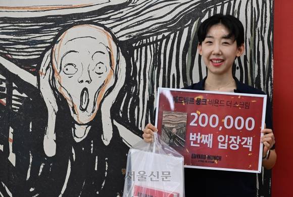 이날 오전 20만 번째 입장 관람객으로 도록 등 20만원 상당의 선물을 받은 행운의 주인공 장경아씨가 전시장 앞에서 환하게 웃으며 포즈를 취하고 있다. 도준석 전문기자