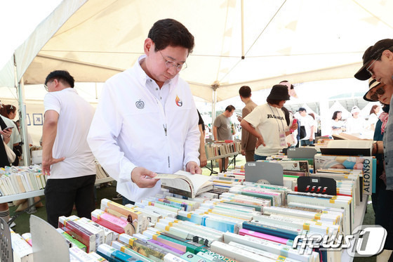 지난해 9월 열린 북 페스티벌에서 이상일 시장이 도서관 제적도서를 1000원에 파는 '북 세일' 부스에서 시민들과 함께 도서를 살펴보고 있는 모습.(용인시 제공)