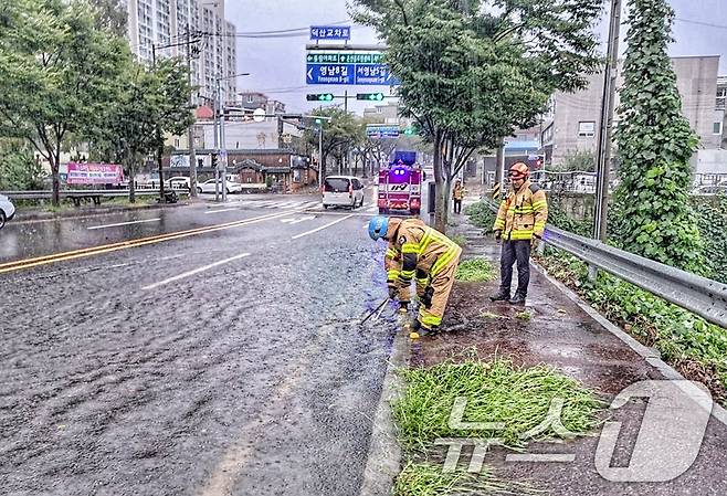 호우경보가 내려진 21일 울산 울주군 온산읍 덕산교차로에서 빗물이 역류해 소방대원이 안전 조치를 하고 있다. (울산소방본부 제공) 2024.9.21/뉴스1 ⓒ News1 조민주 기자