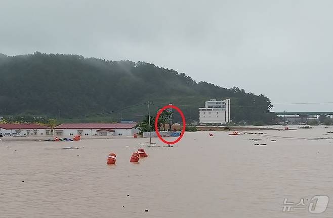 21일 김해시 신문동 마찰교 인근 농막 지붕 위에 고립된 60대 남성이 구조를 요청하고 있다.(경남소방본부 제공)