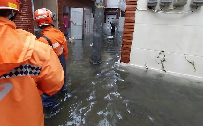 21일 오전 부산 부산진구 범천동 한 마을 골목이 폭우로 사람의 무릎 높이까지 물에 잠겨 있다. 부산소방 제공