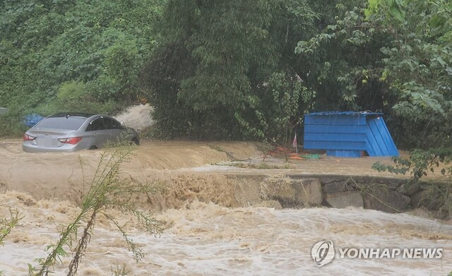 21일 오전 경남 김해시 주촌면 내삼천이 폭우에 불어나면서 차량이 물에 잠겨 있다. 연합뉴스