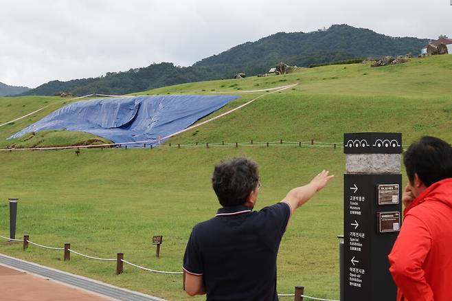 지난 21일 폭우로 일부가 붕괴한 유네스코 세계문화유산인 경남 김해시 대성동고분군 사고 현장에서 22일 시 관계자가 상황을 설명하고 있다.