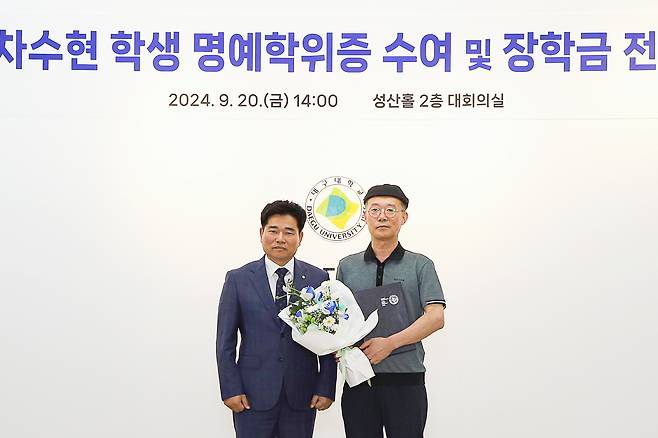 Cha Min-su (right), the father of late Cha Su-hyeon, poses with Daegu University President Park Soon-jin after receiving an honorary degree on behalf of his daughter on Friday. (Daegu University)