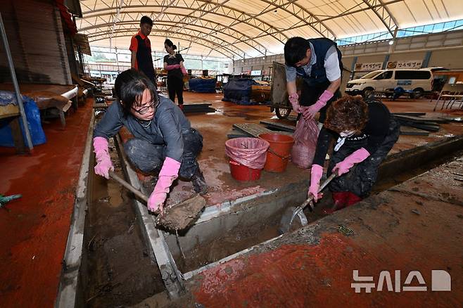 [진도=뉴시스] 이영주 기자 = 22일 오후 전남 진도군 조금시장에서 상인들이 배수로를 정비하고 있다. 진도에는 전날 오후 시간당 최대 112.2㎜ 폭우가 쏟아져 조금시장 일대와 곳곳이 침수됐다. 2024.09.22. leeyj2578@newsis.com