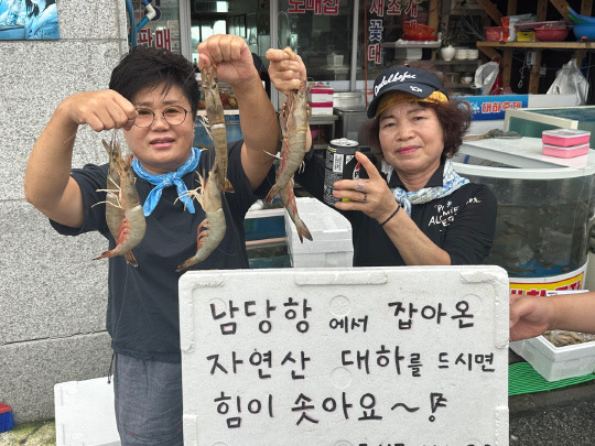 충남 홍성 남당항 상인들이 대하를 들어보이고 있다. 홍성군 제공.