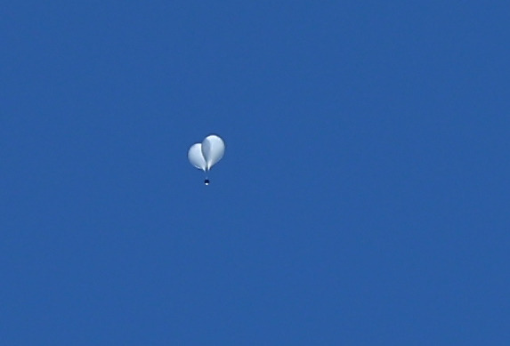 An object assumed to be a pair of balloons carrying trash is seen in the sky above Yongsan District, central Seoul, on Monday morning. [YONHAP]