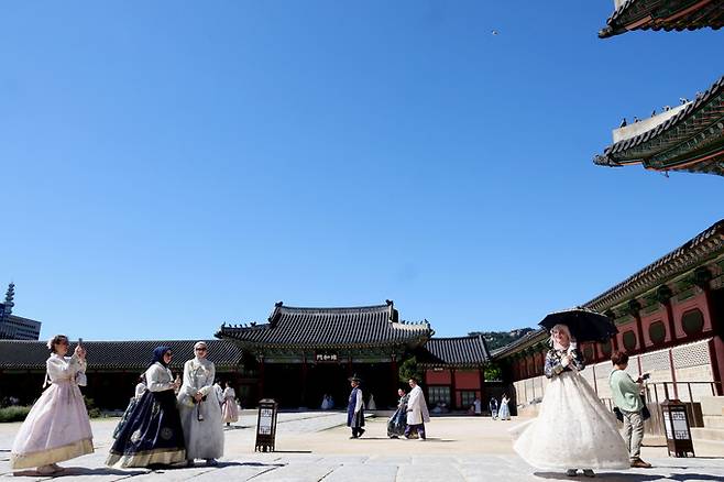 완연한 가을날씨를 보인 23일 서울 종로구 경복궁을 찾은 관람객들이 고궁과 파란 하늘을 배경으로 기념사진을 찍고 있다.