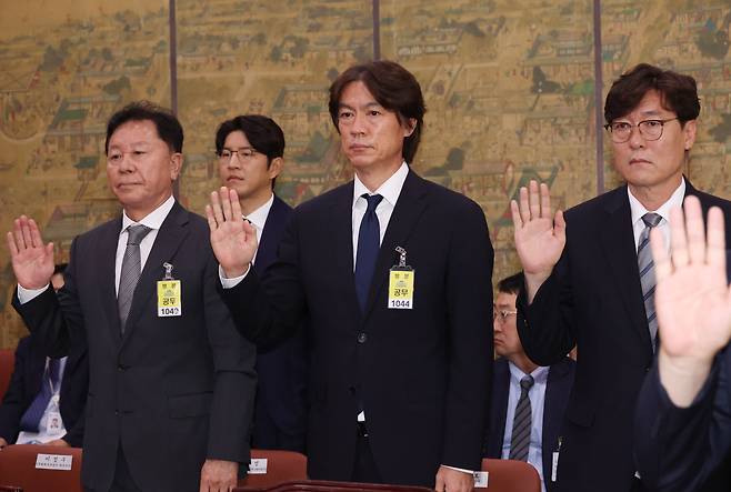 대한축구협회 정해성 전 전력강화위원장(왼쪽부터)과 축구 국가대표팀 홍명보 감독, 이임생 대한축구협회 기술총괄이사가 24일 국회에서 열린 문화체육관광위원회 전체회의에 출석, 증인 선서를 하고 있다./연합뉴스