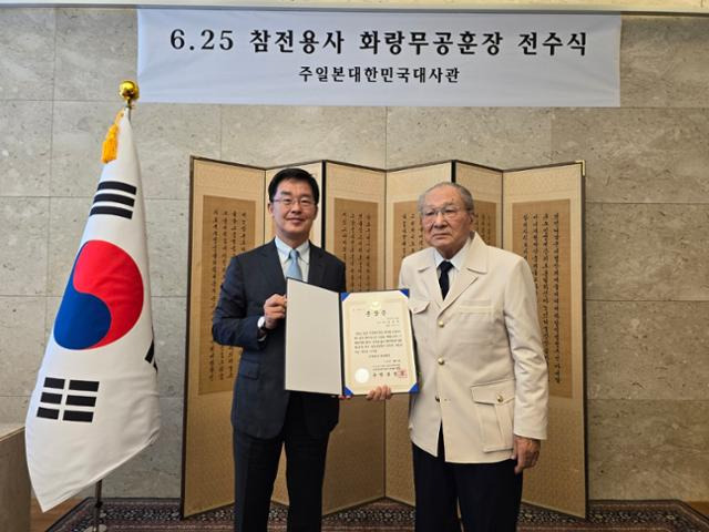 박철희(왼쪽) 주일 한국대사와 화랑무공훈장을 받은 송성석씨가 24일 일본 도쿄 주일 한국대사관에서 열린 6·25전쟁 참전용사 화랑무공훈장 전수식에서 훈장증을 들고 기념사진을 촬영하고 있다. 주일한국대사관 제공